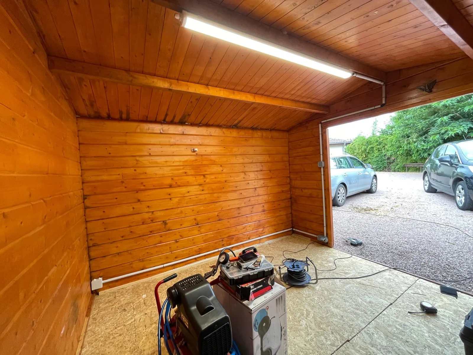 Garage en bois éclairé par réglette LED, goulottes